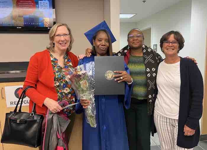 photo of Rosalyn in a cap and gown centered among three of her tutors
